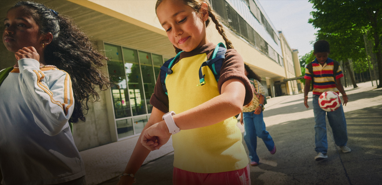 Close-up of a child wearing a backpack using an Apple Watch.