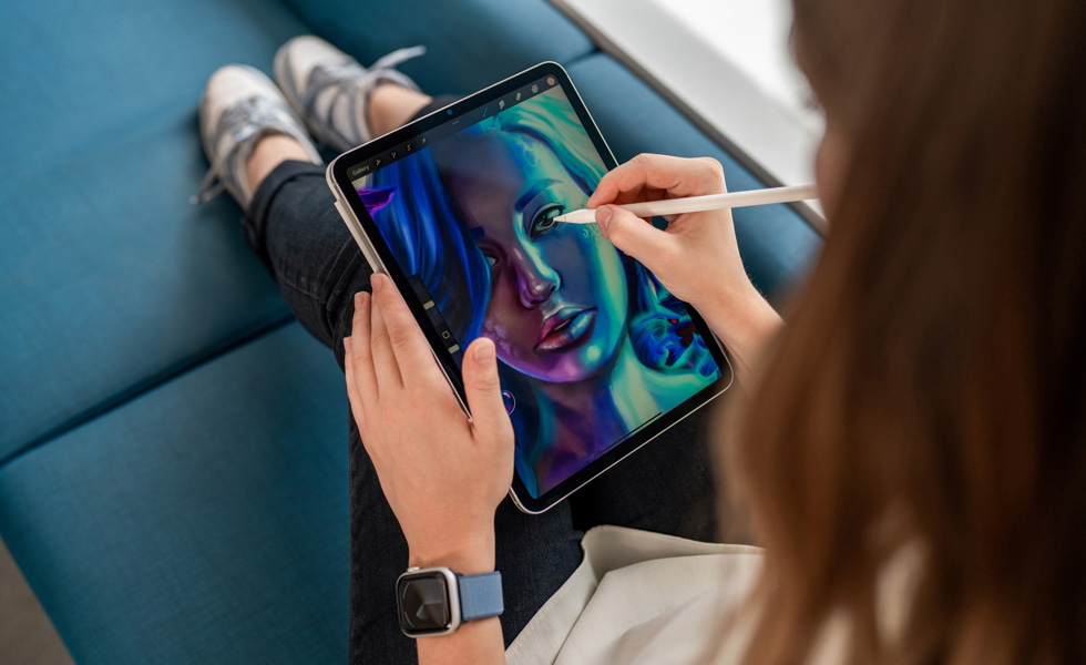 Eine Studentin hält ein iPad auf ihrem Schoß und zeichnet mit einem Apple Pencil in der Procreate App