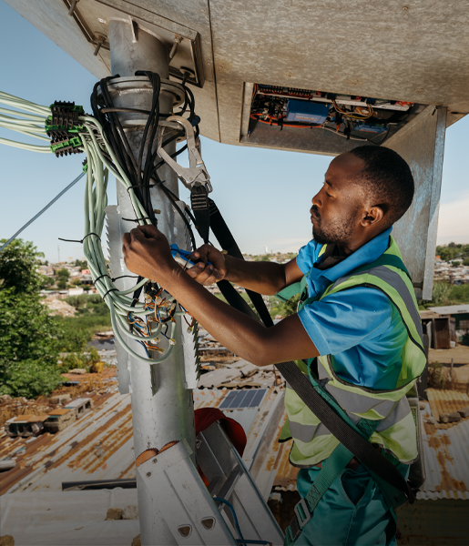 Un uomo di colore su una scala lavora su dei cavi elettrici