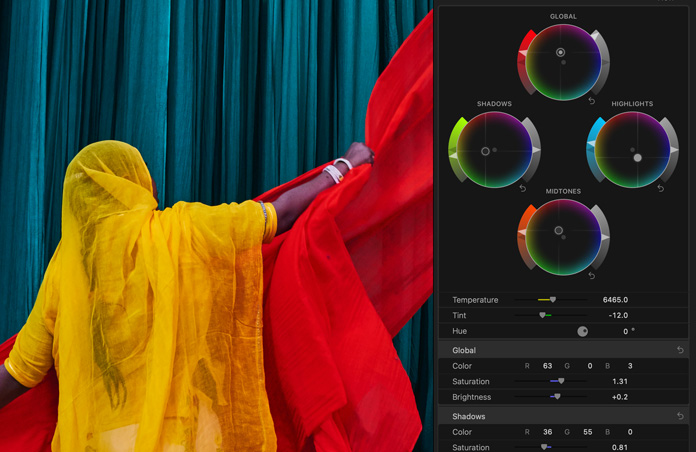Tela mostrando uma mulher vestindo um sári amarelo brilhante e segurando véus vermelhos contra um fundo azul, demonstrando as ferramentas de gradação de cores