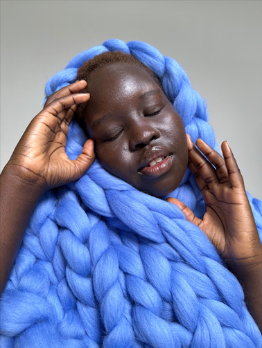 Photo d’une femme enveloppée d’une couverture bleue. La photo a été prise avec l’objectif principal 1x.