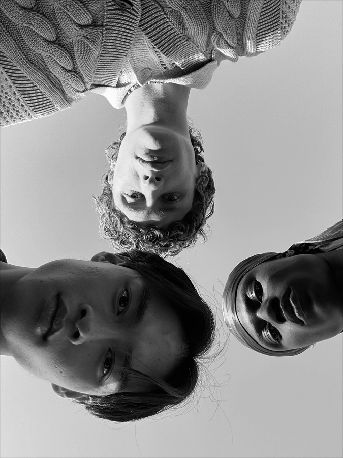 Grupinukė: trys žmonės stovi skirtingu atstumu nuo fotoaparato. Ši nuotrauka buvo padaryta naudojant „TrueDepth“ kamerą.