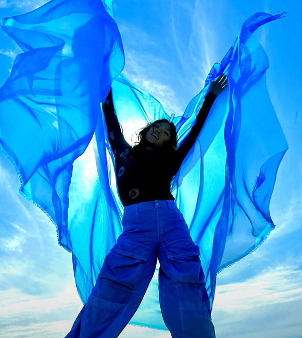 A vibrant photograph of someone in a oversized blue top, taken with the TrueDepth camera