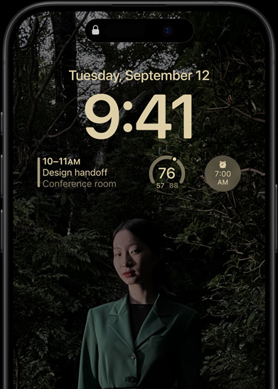 Az iPhone 15 Pro mindig bekapcsolt kijelzője, amelyen a zárolási képernyő jelenik meg egy naptárwidgettel, egy időjáráswidgettel és egy ébresztési widgettel