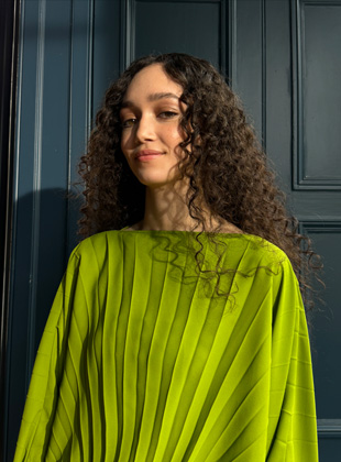 Фотознімок жінки в зеленій сукні, що було зроблено на об’єктив 35 мм