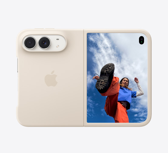 iPhone Duo, Farbe Sternenweiss in Silikon Case in Sand, Querformat, vollständig geöffnet, Dual Fusion Kameras oben links, Case bedeckt die Rückseite und den äusseren Rand des vorderen Displays, die rechte Seite mit äusserem Display mit dem Bild einer Person, die unter einem wolkenbedeckten blauen Himmel steht