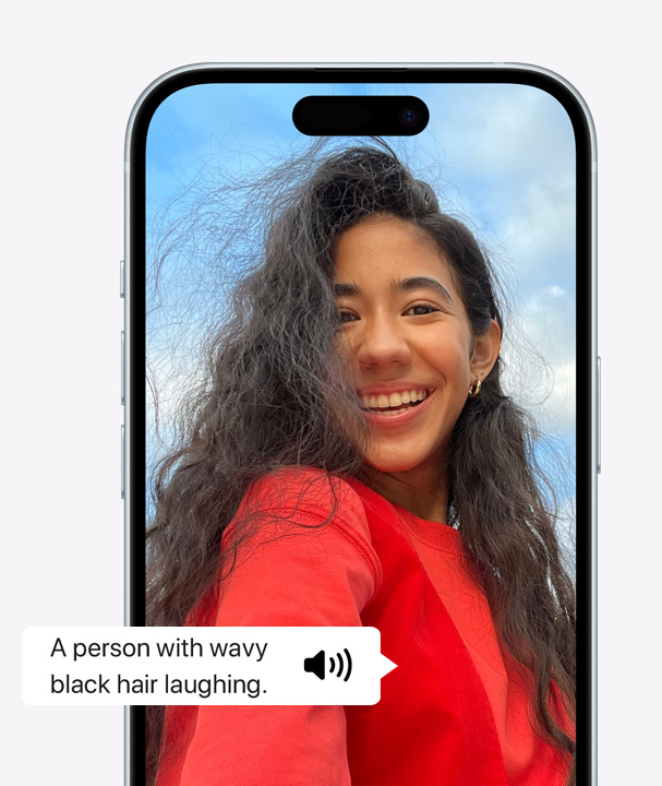 一张iPhone使用VoiceOver描述屏幕上一个人波浪状头发笑的细节的图片。