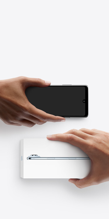 Két egymás felé nyújtott kéz, a bal oldaliban egy doboz nélküli androidos telefon, a jobb oldaliban egy új iPhone Air a dobozában.