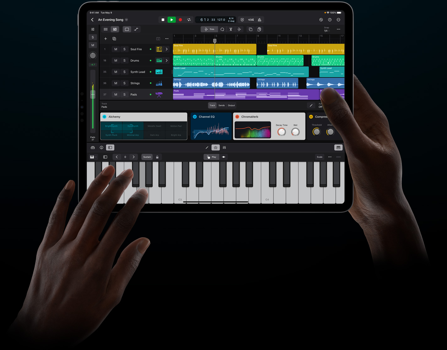 Hände, die ein iPad Pro halten und berühren, um ein virtuelles Instrument in Logic Pro für iPad zu spielen.