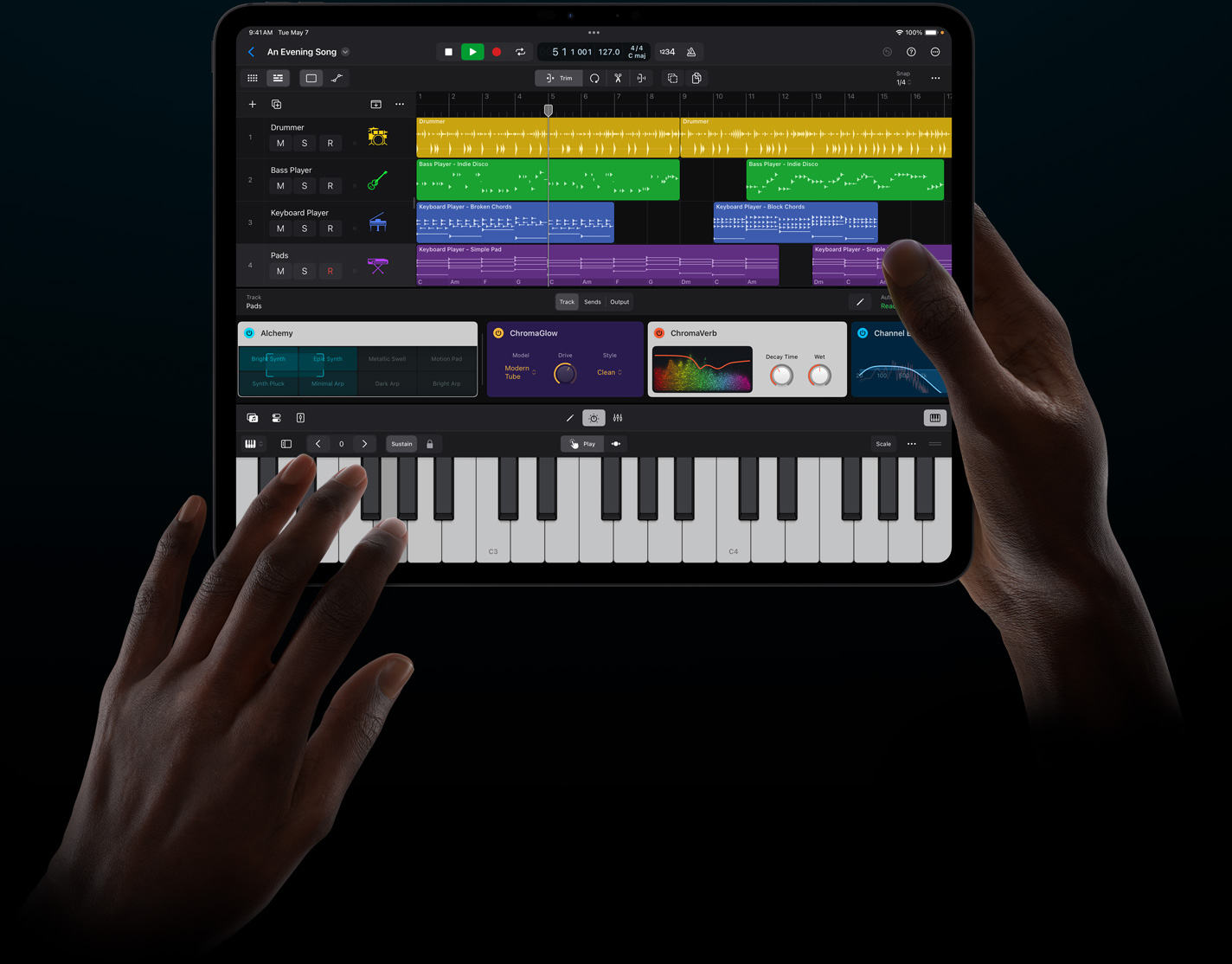Duas mãos seguram um iPad Pro e tocam um instrumento virtual no Logic Pro para iPad.