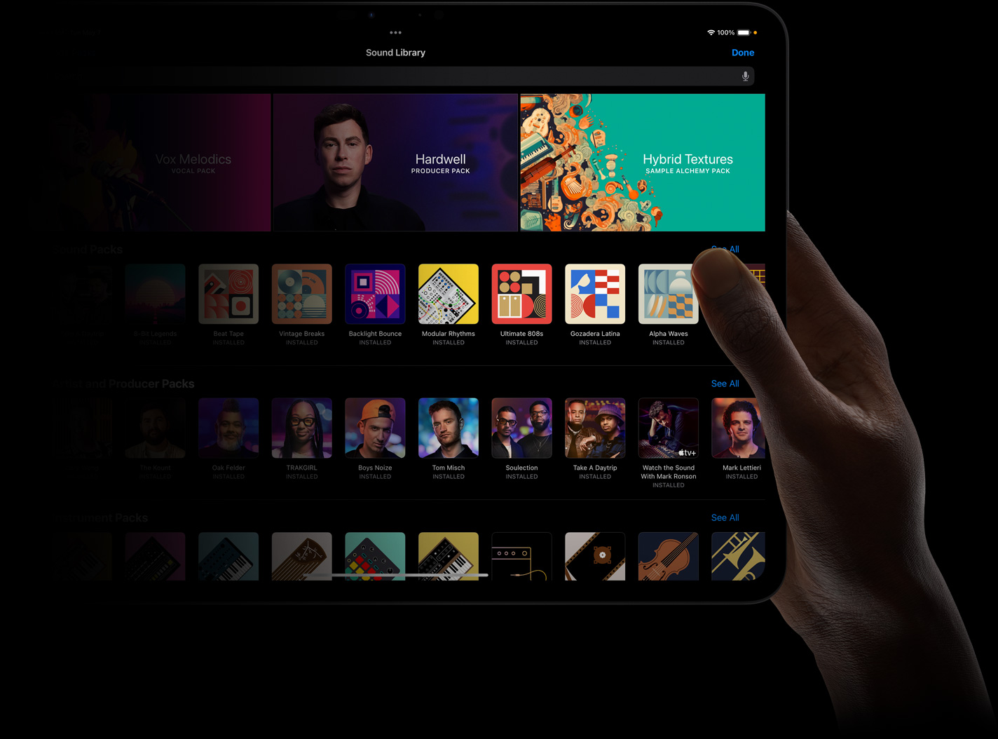 Imagem de uma mão segurando um iPad Pro que mostra uma biblioteca de sons na tela.