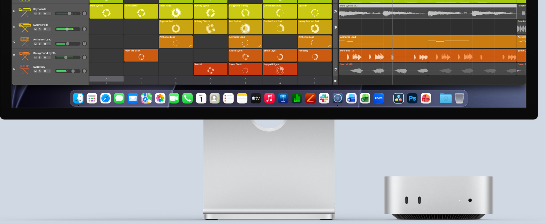 Mac mini front, tucked under Studio Display, with Logic Pro interface on screen, and productivity apps in Dock at the bottom
