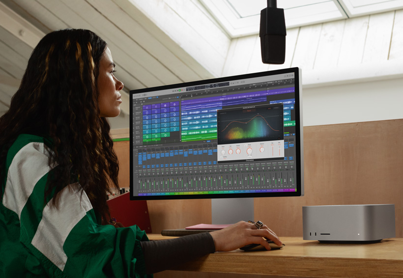 En lydtekniker jobber på Mac Studio med Studio Display