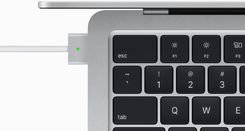 Pohľad zhora na kábel MagSafe zapojený do MacBooku Air v striebornej farbe