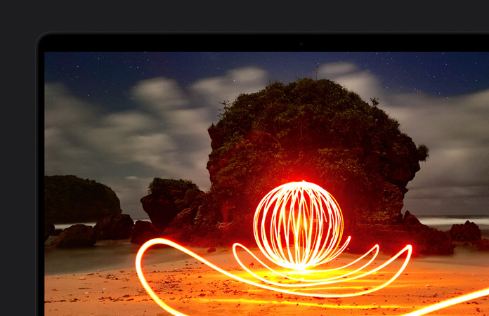 MacBook Pro 螢幕畫面是海灘上極明亮的藝術裝置，展示 Extreme Dynamic Range 技術為顯示器帶來的出色對比