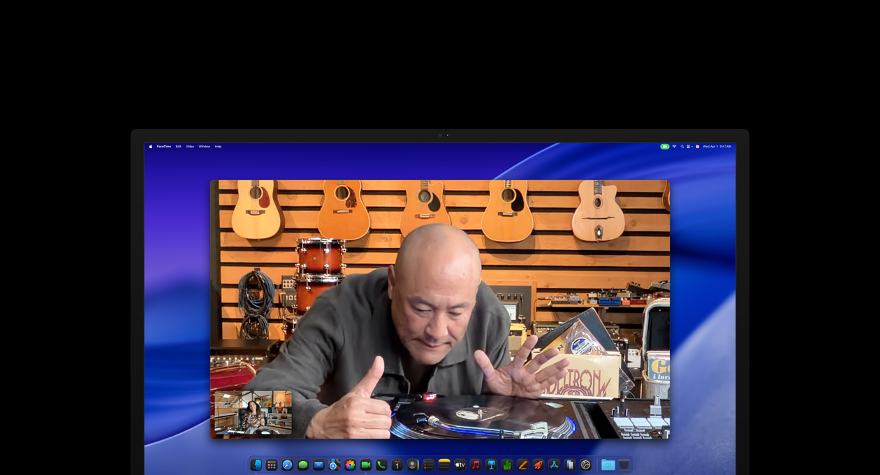 在 Studio Display XDR 上進行視像通話期間，在影音店裡的一個人靠近唱碟機細看，人物置中功能讓他保持在螢幕中央