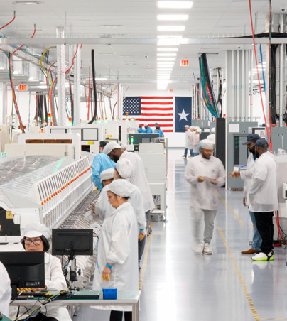 Employees in full-coverage work suits work in an AI server assembly facility