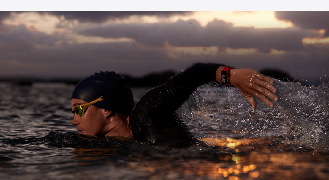 O femeie poartă un Apple Watch Series 9 în timp ce înoată într-un decor natural.