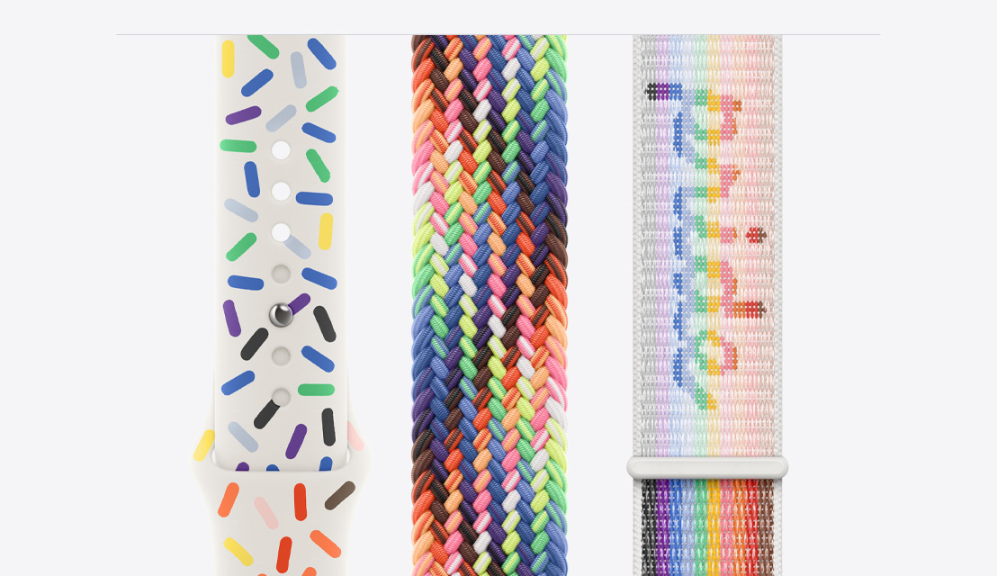 Three Apple Watch bands laying flat, the Pride Edition Sport Band on the left, the new Pride Edition Braided Solo Loop in the middle, and the Pride Edition Sport Loop on the right.