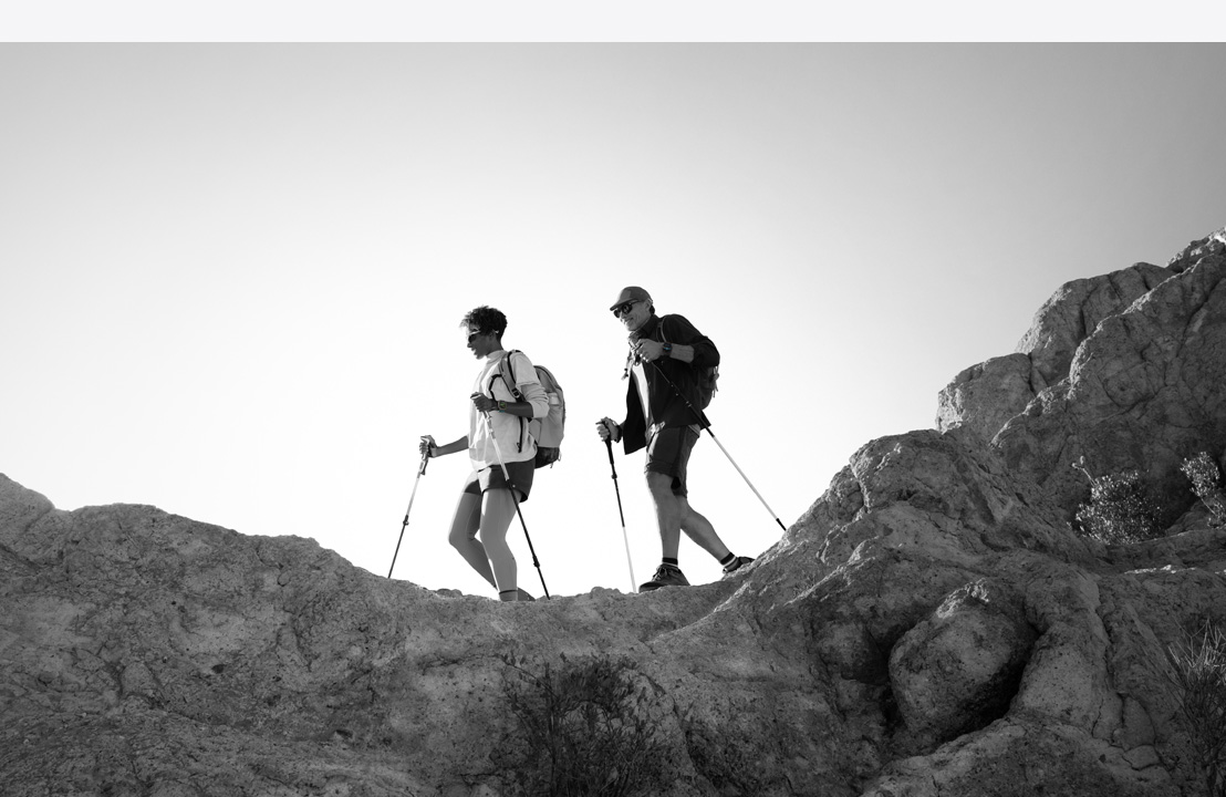 Deux personnes portant une Apple Watch Ultra 3 font une randonnée en montagne