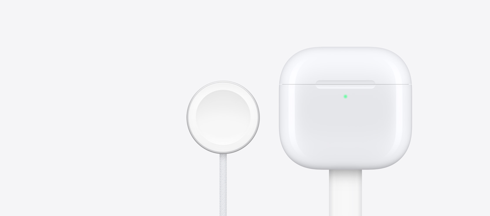 AirPods 4の充電ケース。その横にApple Watchの充電器が置かれている